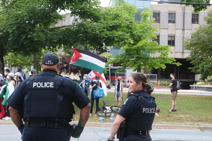 Police offers at Dalhousie on Monday July 29, outside of the Rowe building and facing pro-Palestine student protesters who were removed from the building that afternoon, following the dismantling of their 78-day encampment that morning by Dal Security. After protesters were removed, Dal issued an alert that its Halifax campuses were shut down until further notice.