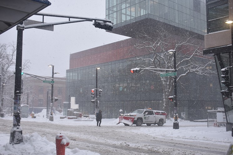 A pedestrian crosses in front of the Halifax Central Library.