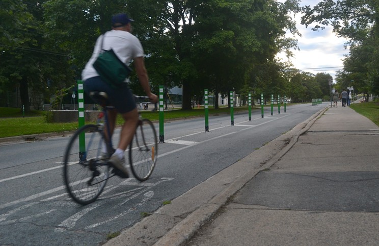 A cyclist rides in a bike lane on University Avenue.