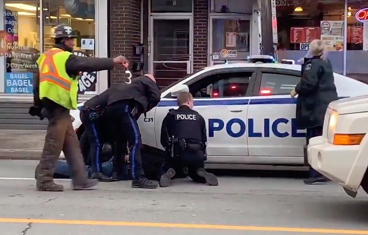 In the bystander video of Fred's arrest, a construction worker gives a pair of handcuffs to the police.